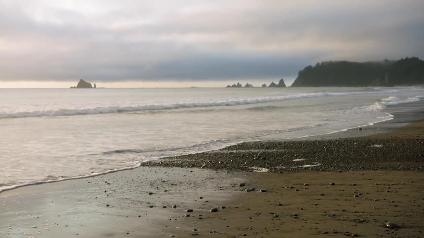 Low waves crashing on beach during a cloudy day