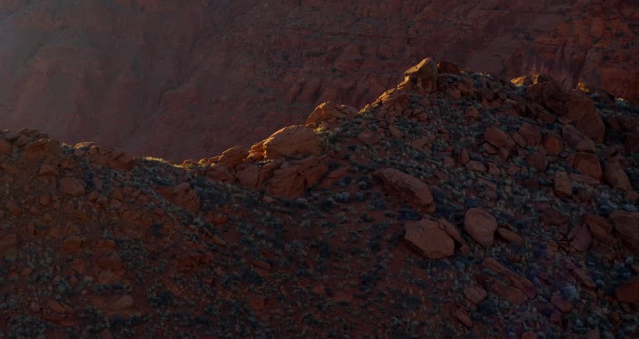 A canyon with rocks and sunlight with the sky and clouds in the background