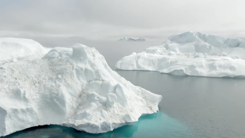 White glaciers against water and an overcast sky
