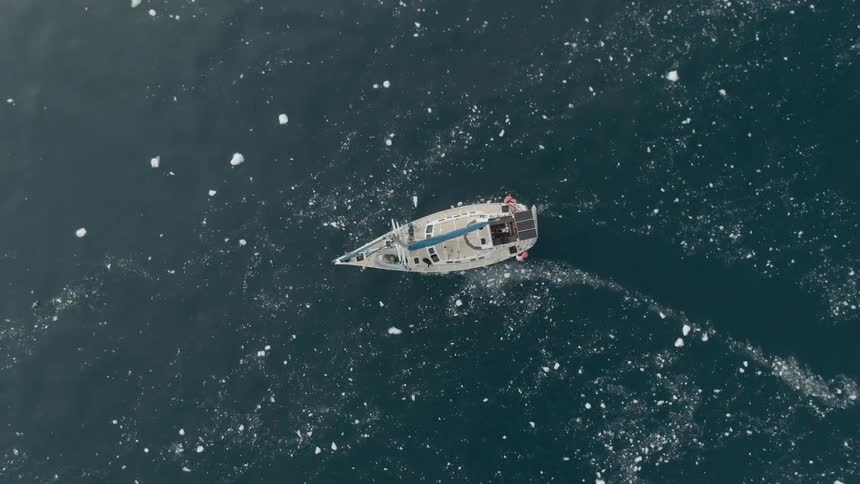 A boat traveling in the ocean with ice