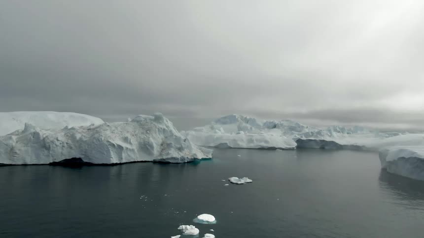 Aerial view of white ice iceberg polar cap floating on the ocean