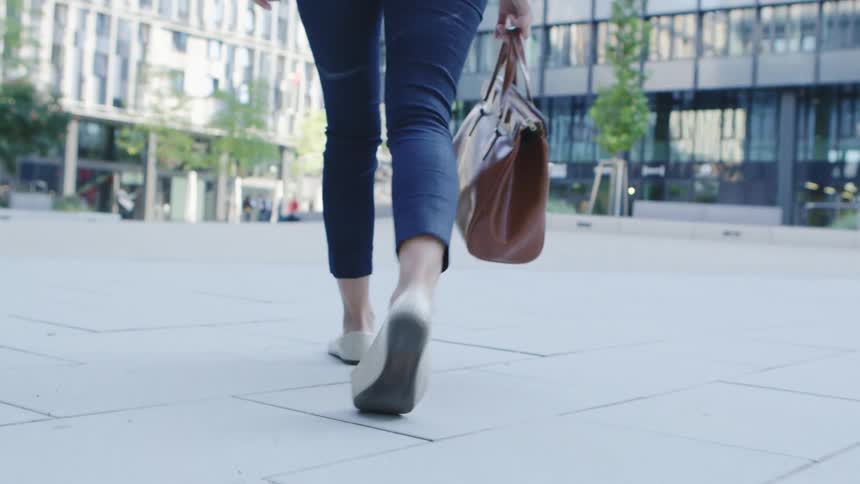 Woman walks across plaza toward building entrance