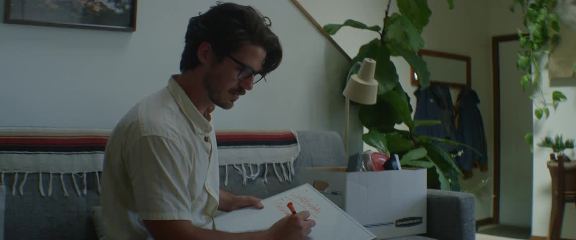 Man writing on a whiteboard sitting on a couch