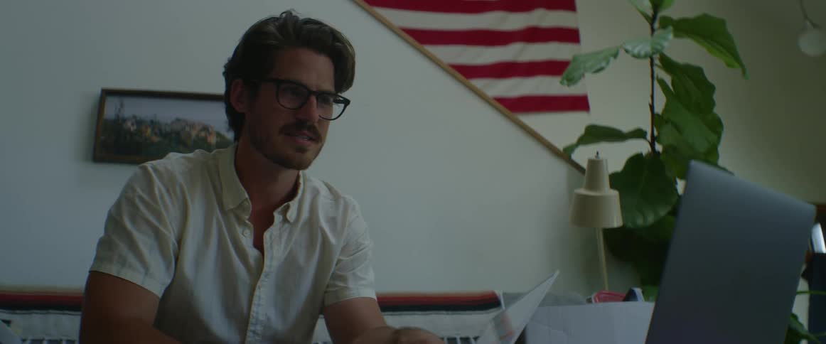 Man sitting at home on sofa video chatting on laptop