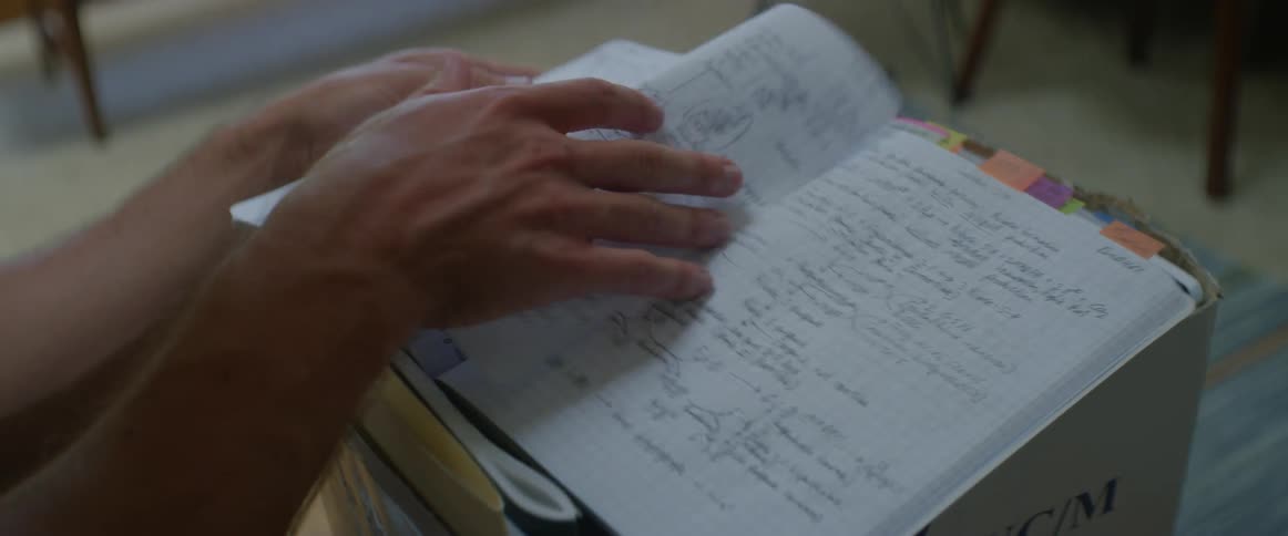 A person flips through a notebook filled with notes