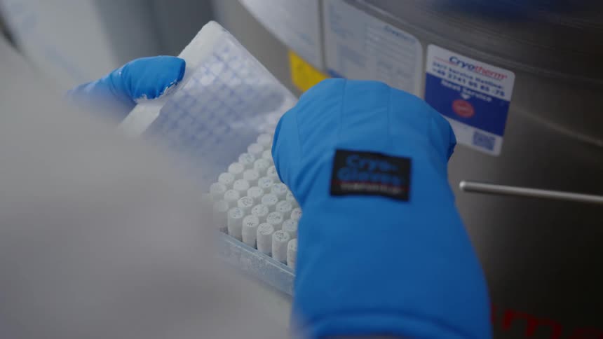 Someone taking chemicals out of a freezer to check them