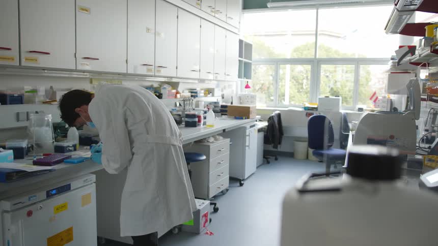 Man wearing a lab coat working inside of a medical lab