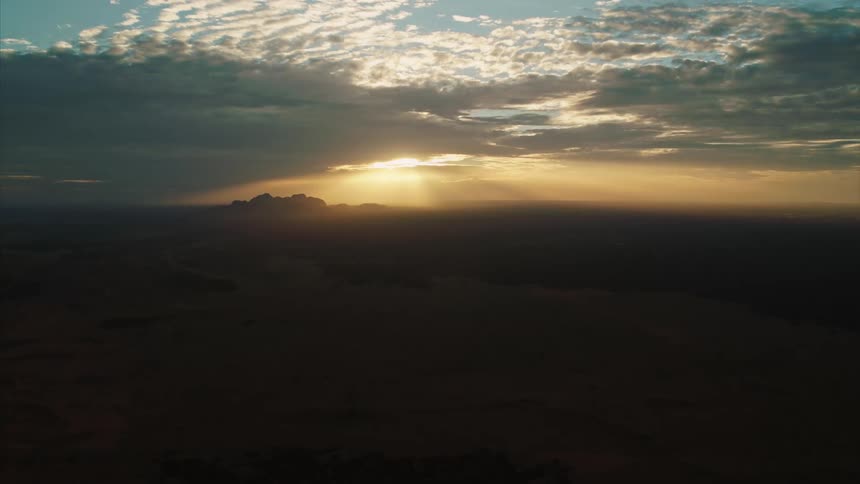 The sun rises in the horizon on a cloudy day