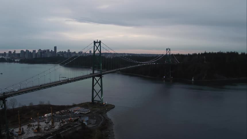 Lions Gate suspension bridge spans water leading into Stanley Park and downtown Vancouver