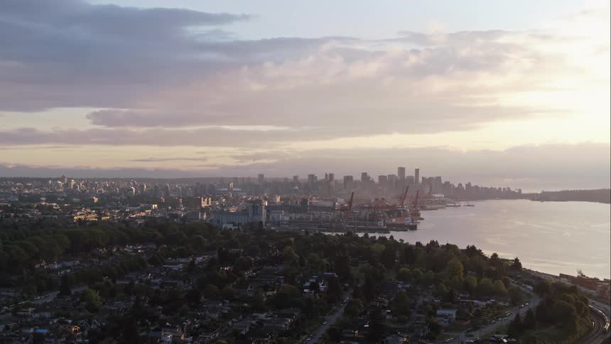 An aerial view of a downtown Vancouver in last sunset light is displayed