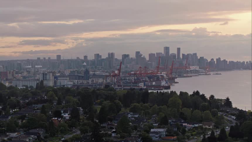 The sun sets behind downtown Vancouver neighbourhoods and port