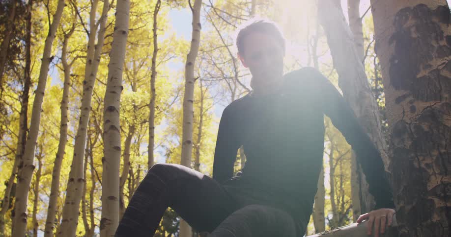 A woman in black sits on a log
