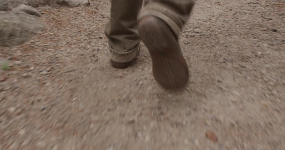 Person walking quickly on a rock and dirt trail