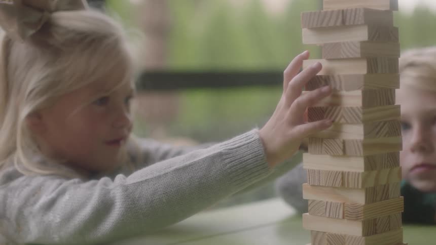 Children sitting at a table playing with wooden blocks