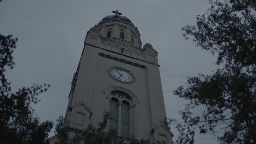 A tall church has a clock tower on the outside