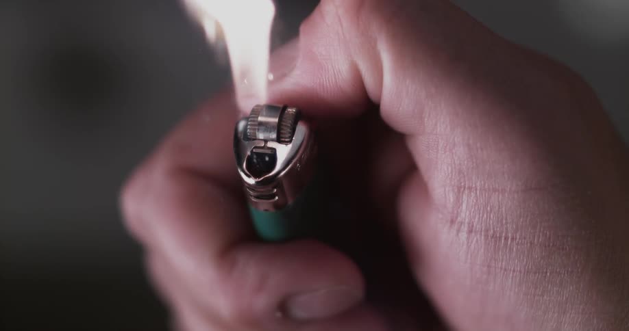 A hand ignites a lighter