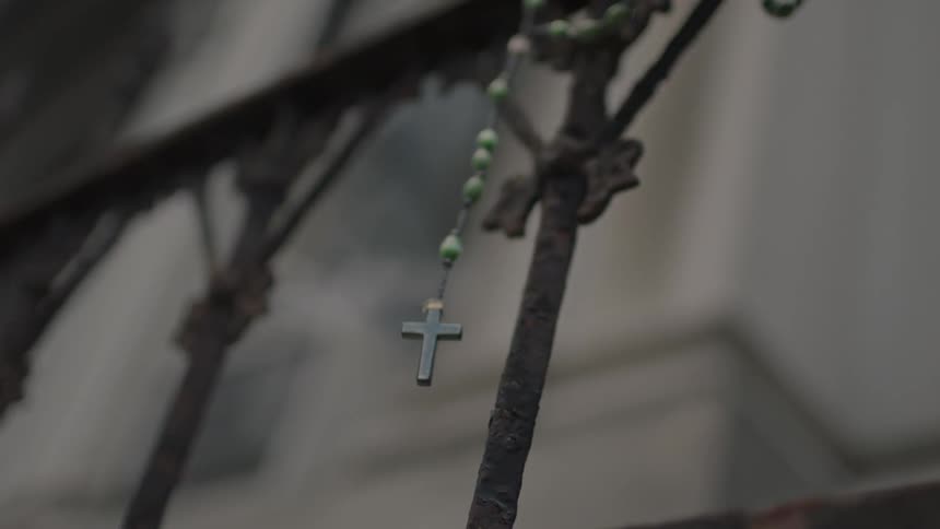 A crucifix hangs on a railing