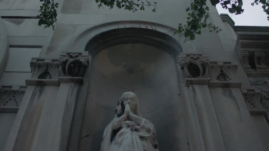 Close up of a statue in front of a stone building