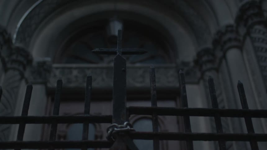A chain around a wrought-iron gate in front of a church