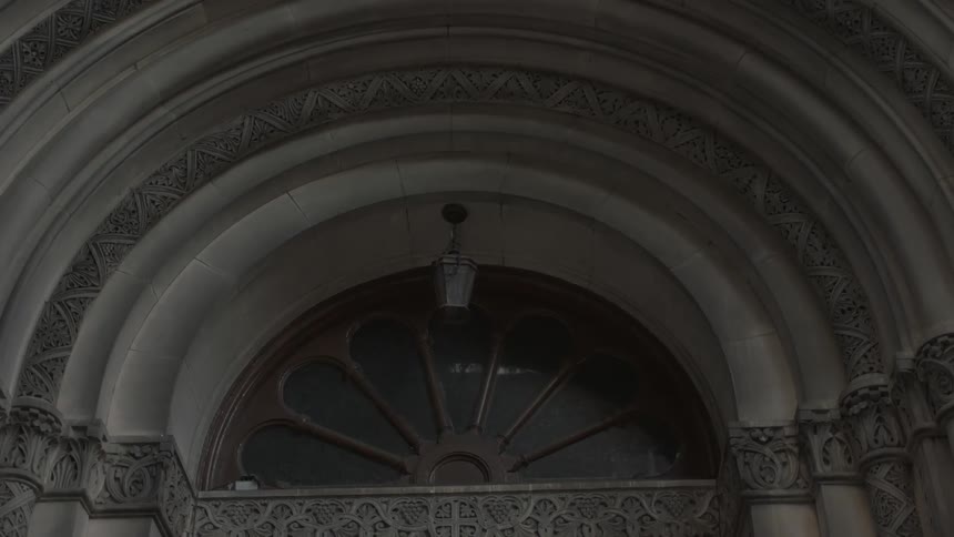 Close up of the arch of an entrance with a half circle window