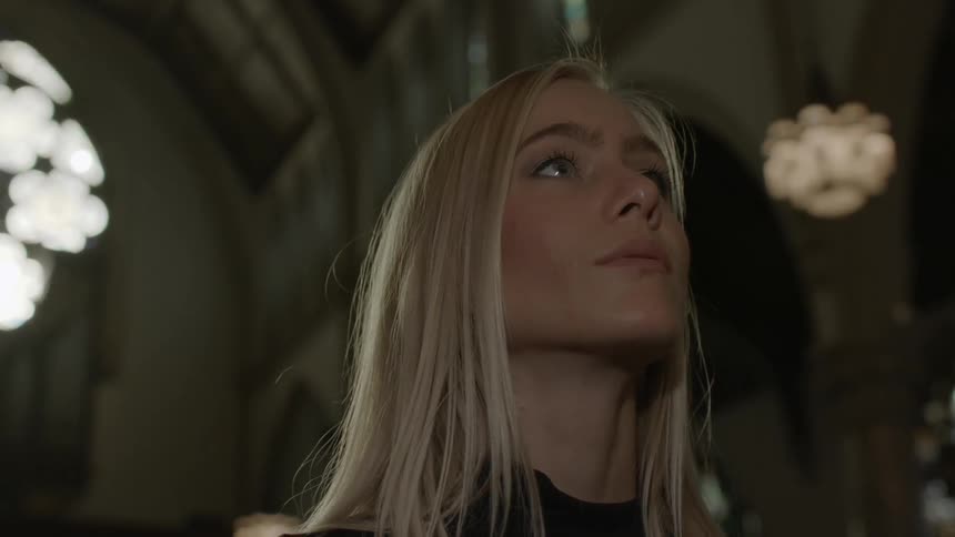 A woman in a church looking toward something in front of her
