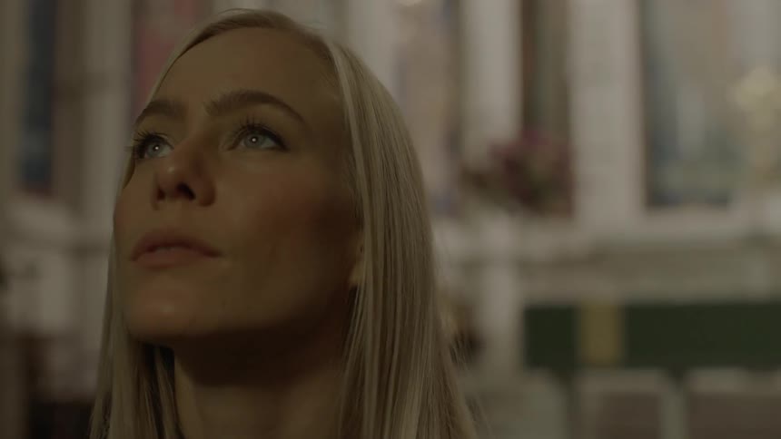 Woman sitting and intently looking forward in a church