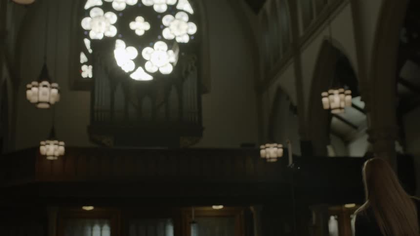 A woman in a church turns around and walks away