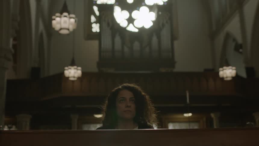 A woman sitting down in a church pew