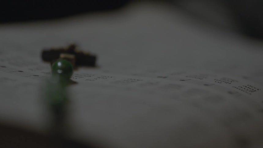 Macro close up on a rosary laying on an open page of a music score