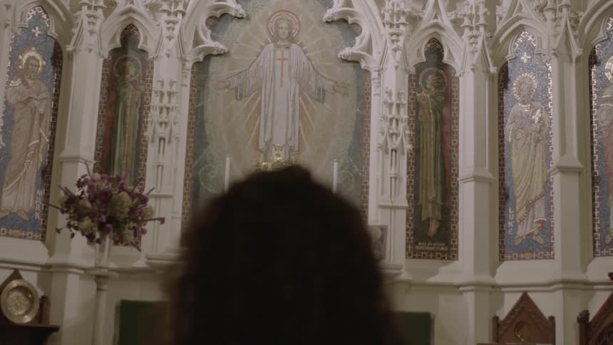 A woman viewing a mural of jesus painted on a church wall