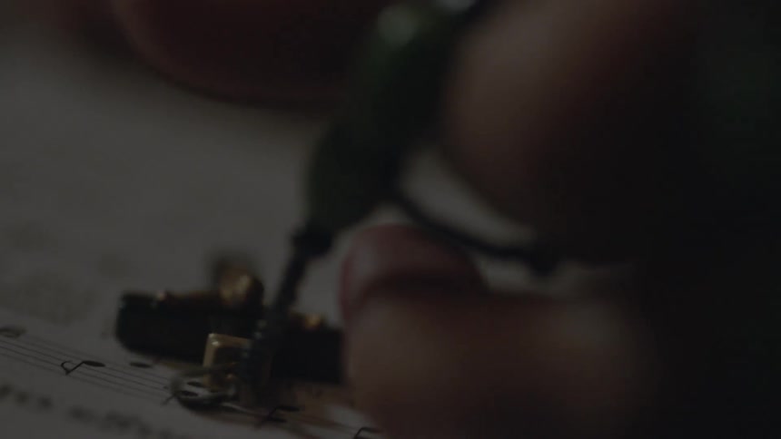 Two fingers touch a rosary