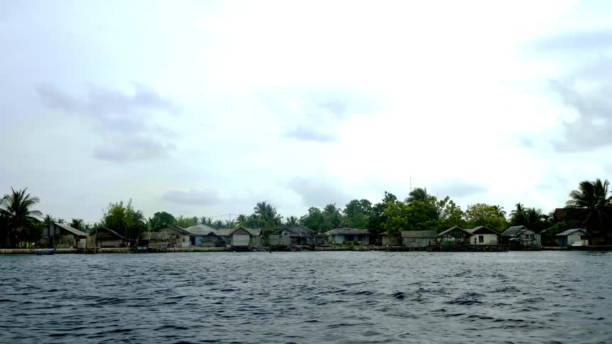A view of an island village seen from aboard a boat on a cloudy day