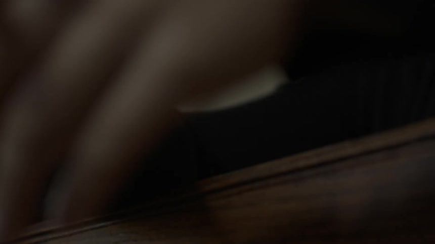 A person's hands and forearms draping over the back of a church pew