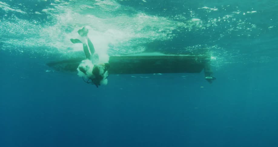 Man diving off a boat in scuba gear