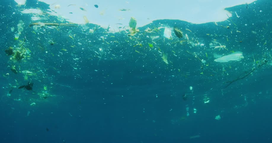 Trash floating in blue ocean water