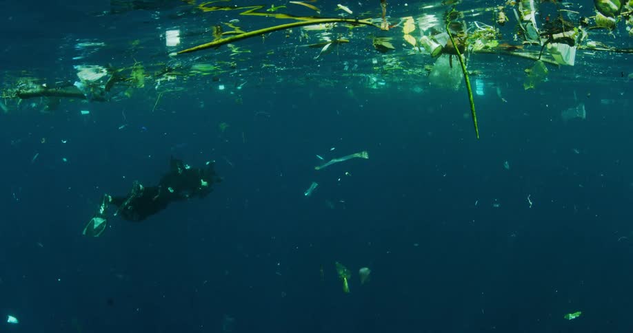 A scuba diver photographing rubbish in the ocean