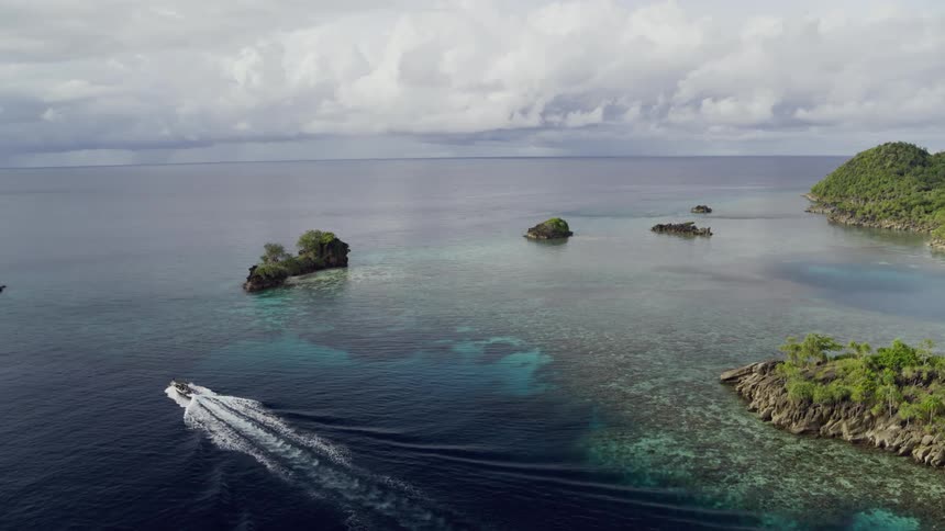 Boat out at sea sailing past islands and islets