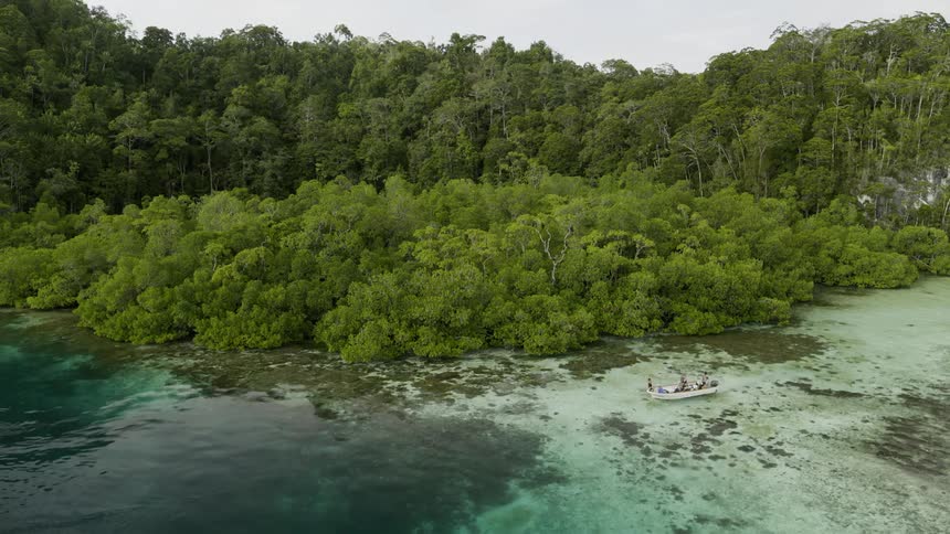A boat floating off the coast of an island