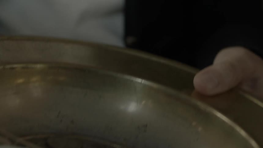 Close up of a collection pan being passed around