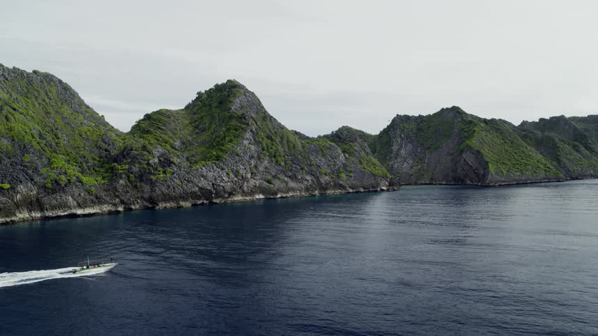 Boat with people passing by an island surrounded by water