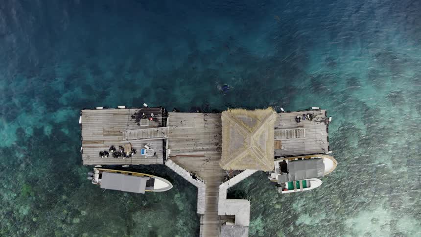 A pier with a hut and boats near the coast with water