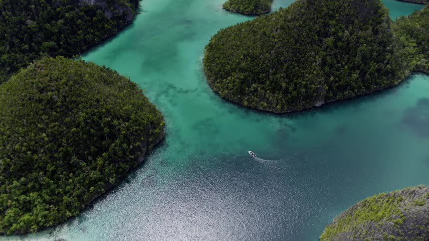 A boat floating around tropical islands in the daytime