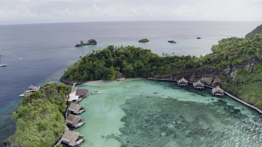 Small huts at a resort in the middle of an island surrounded by water