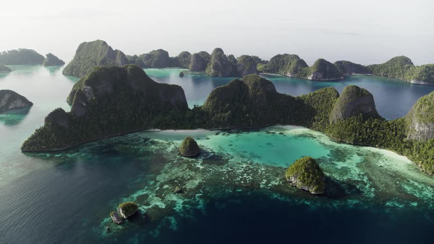 Aerial view of islands in a body of water with sunlight during the day