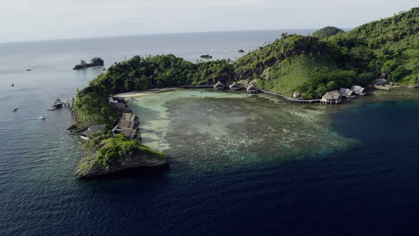Huts on the edge of an island in a bay off a coast in the ocean