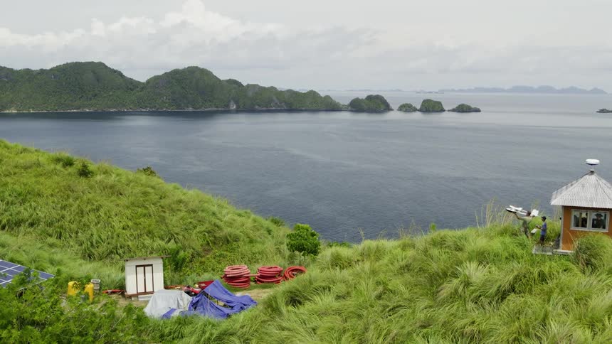 People on an island playing with a small toy plane