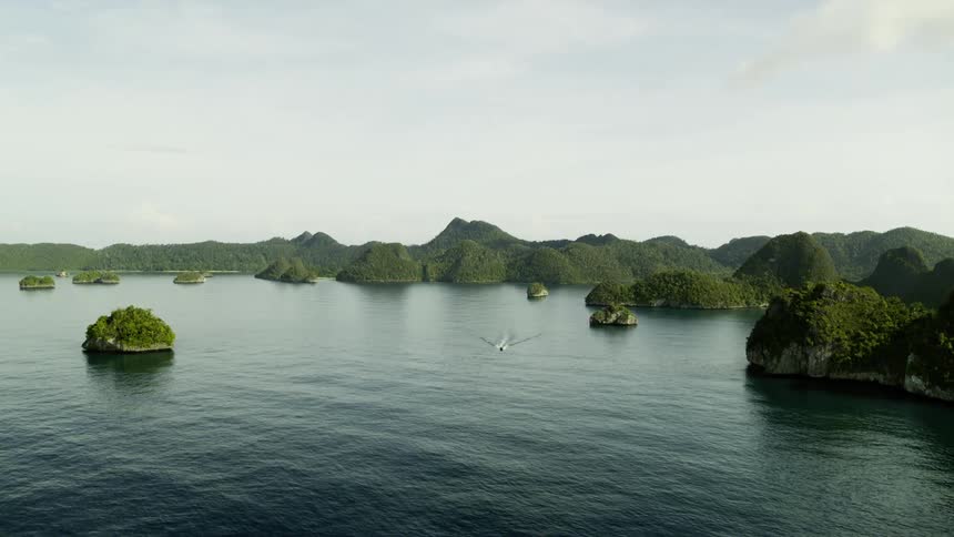 Aerial view of a boat sailing between islands
