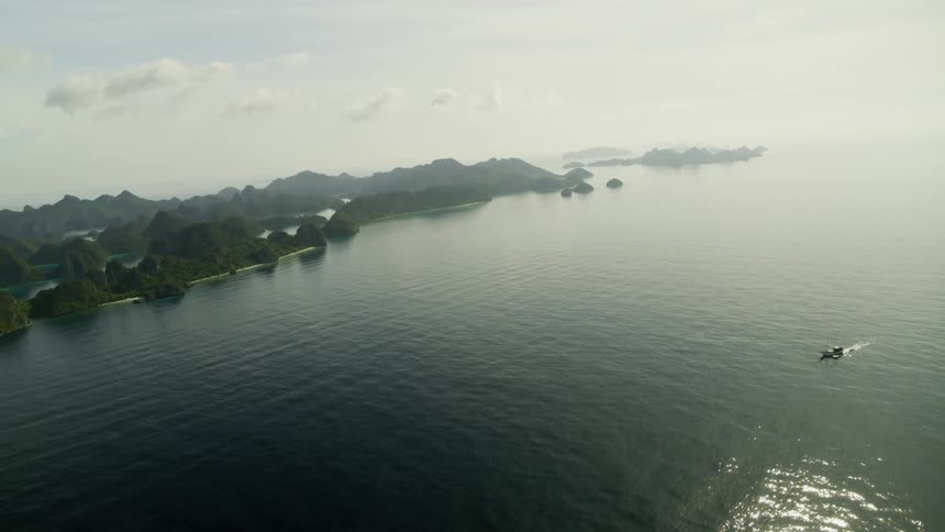 Ocean with a boat against a shoreline in the daytime
