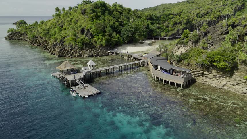 Large island with a coast out in the middle of the ocean with a small boat dock