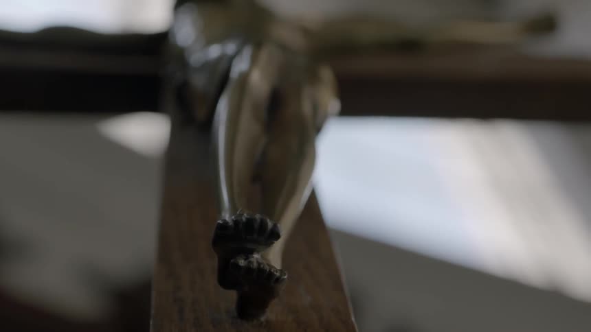 The feet of a statue of jesus on a cross
